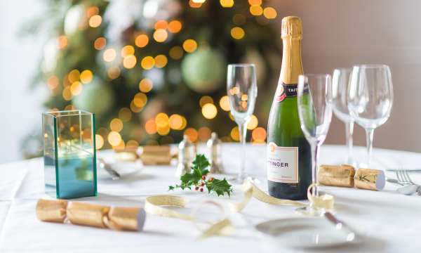 A table set for a Christmas party with decorations and Champagne