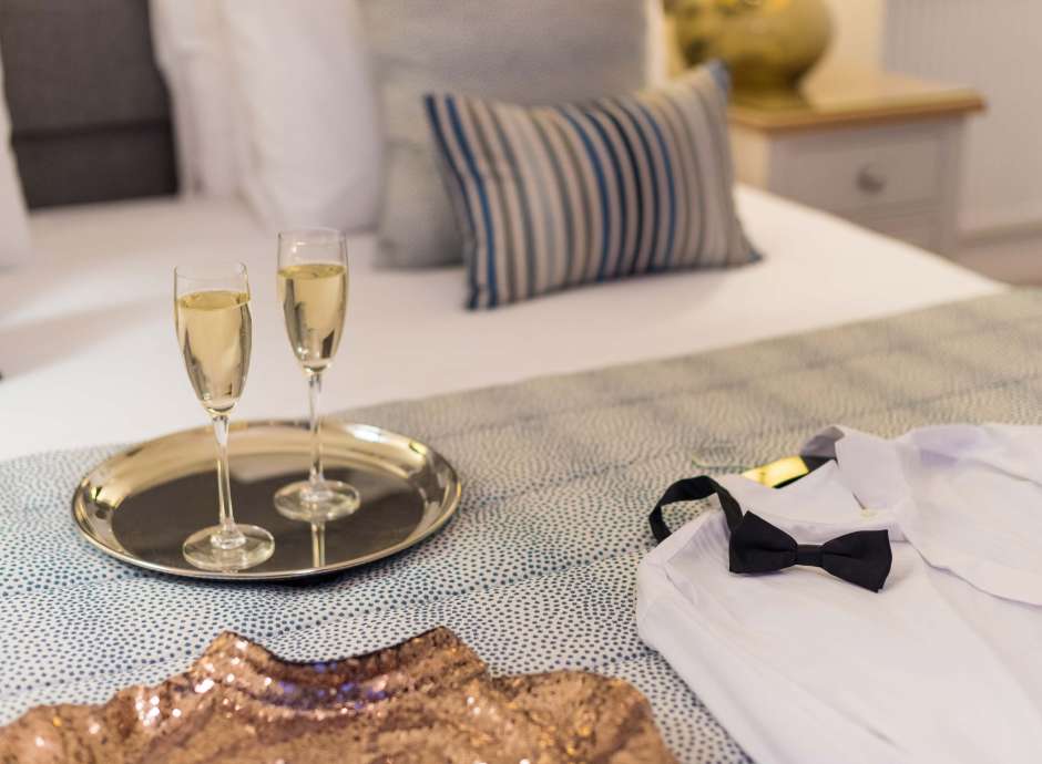 Royal Duchy Hotel Christmas Party Outfits on Bed with Flutes of Champagne