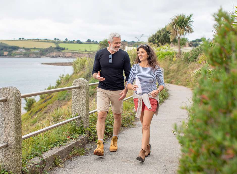 Couple walking in coastal grounds of the Royal Duchy Hotel