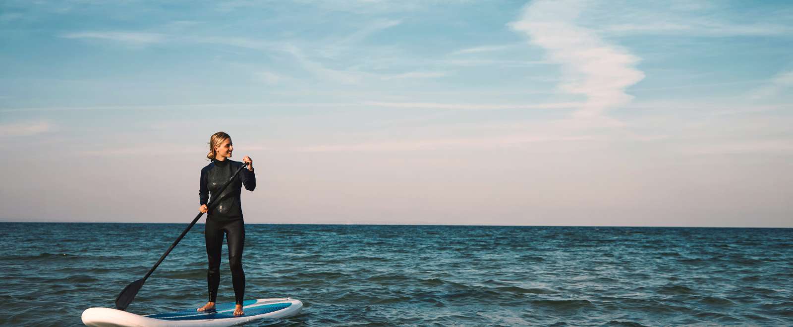 Female Stand up paddleboarding at sea