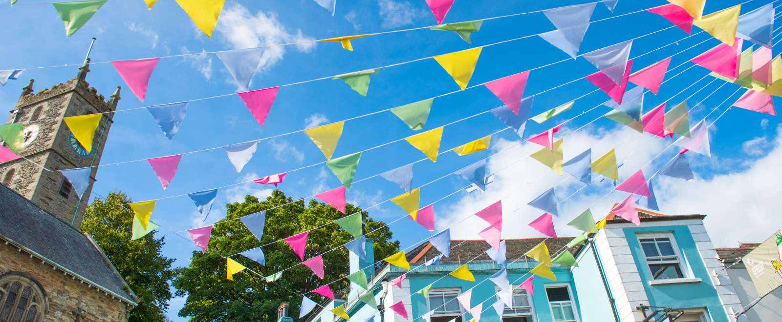 Colourful bunting hung from church on summers day in Falmouth High Street