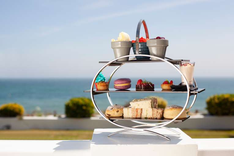 Luxurious afternoon tea served on an outdoor terrace with sea view