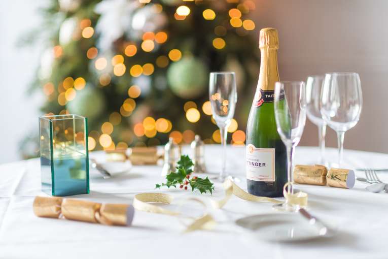 A table set for a Christmas party with decorations and Champagne
