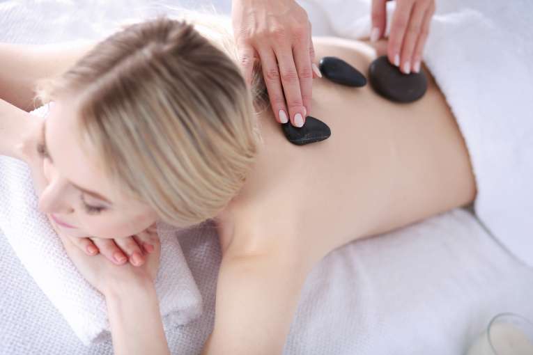 Female guest having hot stone therapy