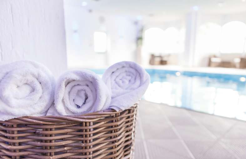 Fresh spa towels in basket next to indoor pool