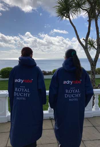 women in royal duchy hotel dry robes looking out to sea
