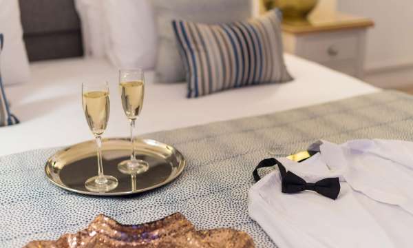 Royal Duchy Hotel Christmas Party Outfits on Bed with Flutes of Champagne