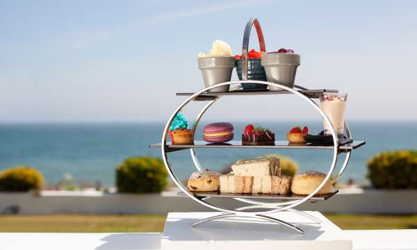 Luxurious afternoon tea served on an outdoor terrace with sea view