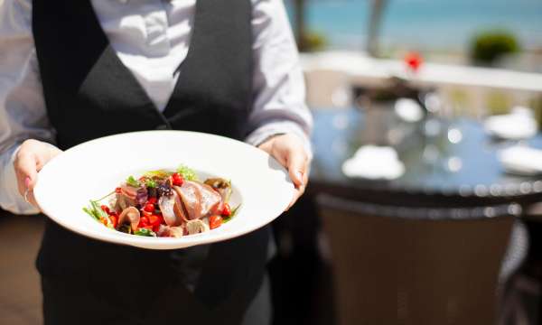 Waiter carrying fresh seafood dish