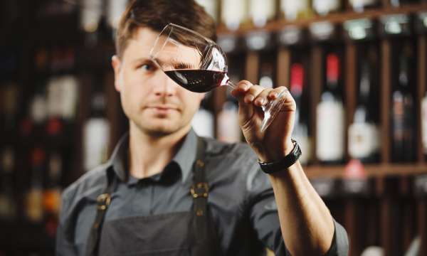 Wine sommelier swilling glass of red wine