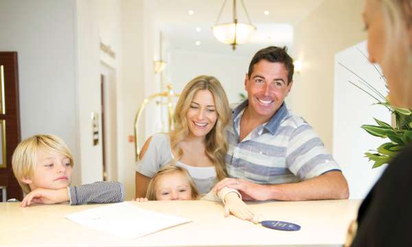 Family of 4 checking into hotel reception