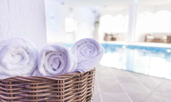 Fresh spa towels in basket next to indoor pool