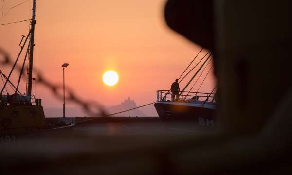 Fisherman preparing boat at sunrise at st-michaels-mount