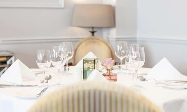 Dining table set for lunch with candle and flowers