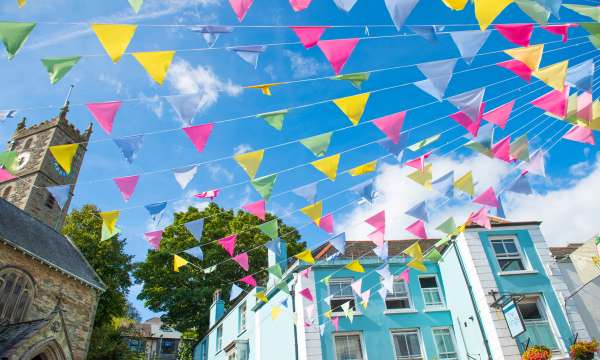 Colourful bunting hung from church on summers day in Falmouth High Street