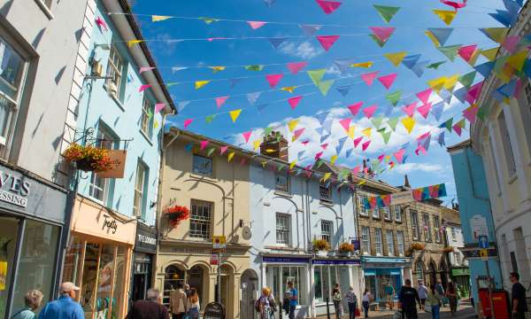 Colourful bunting flying between shops on summers day in Falmouth High Street