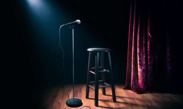 Seat on a stage with a mic 