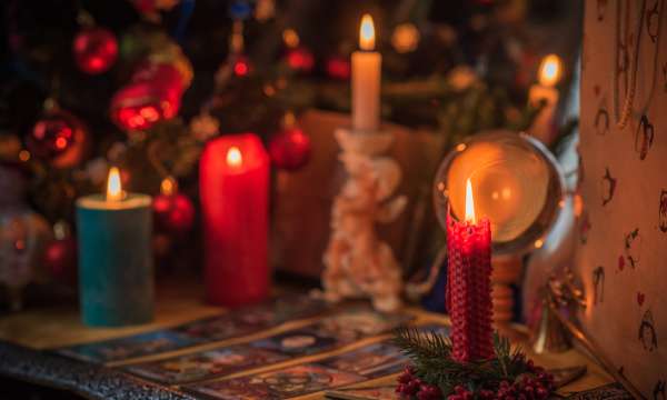 Candles and crystal ball in a dark room with tarot cards on the table