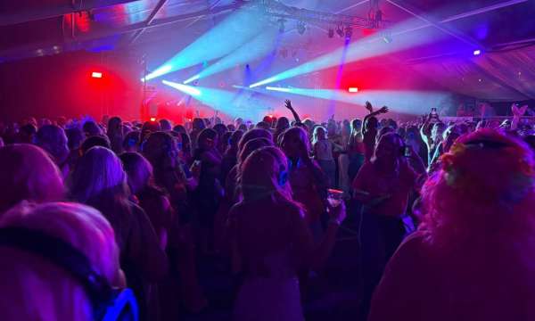 People dancing in a tent with lights at the Falmouth Pink Wig March