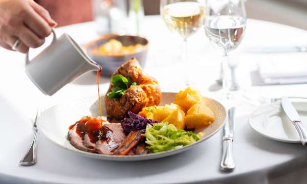 Someone pouring gravy on roast beef at The Royal Duchy Hotel