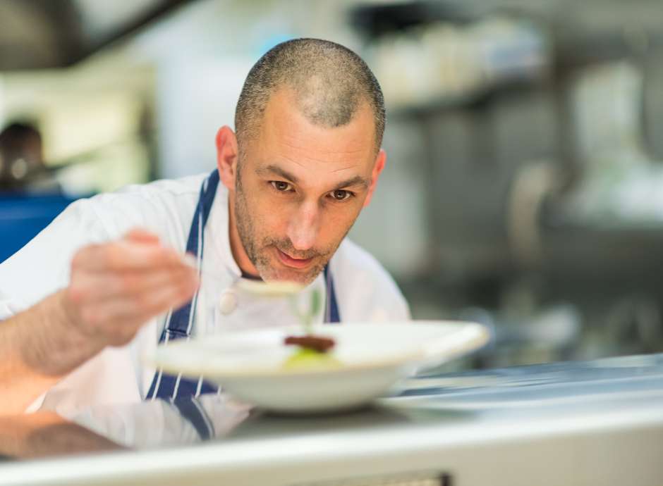 Royal duchy hotel chef John in kitchen serving food.