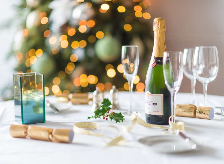 A table set for a Christmas party with decorations and Champagne