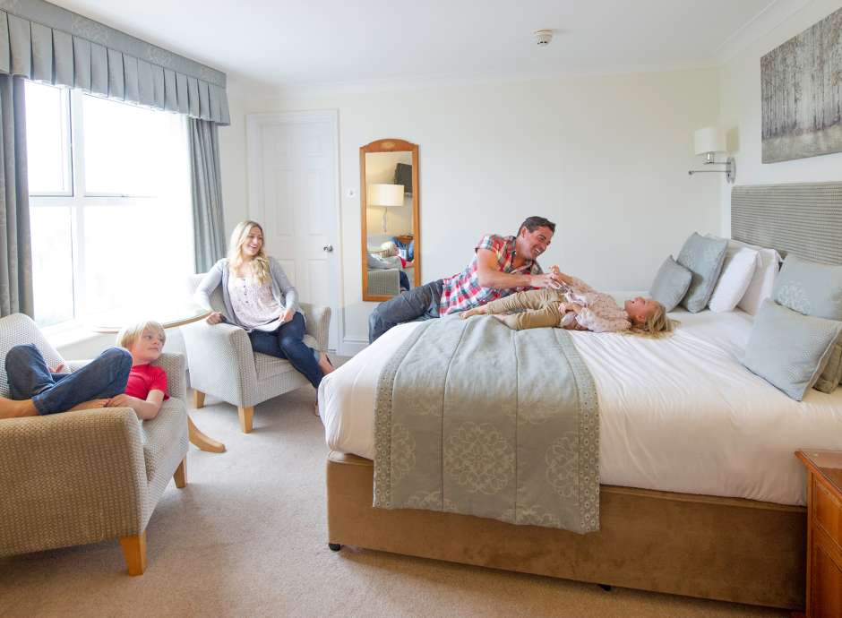 Family of 4 relaxing in hotel room