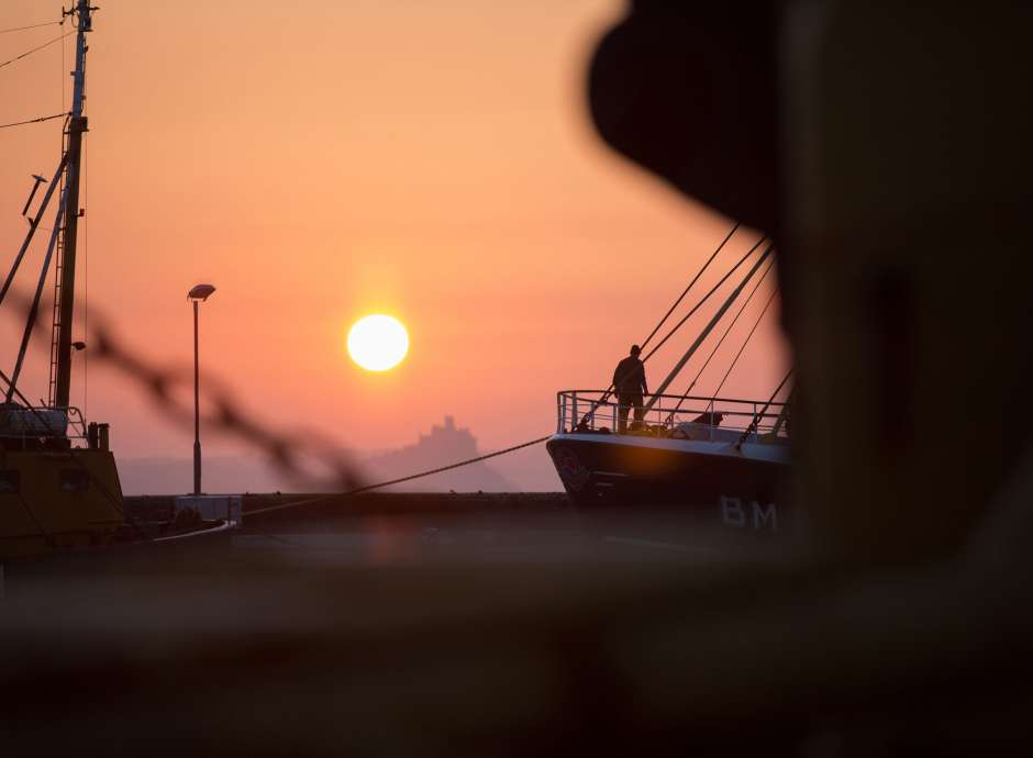 Fisherman preparing boat at sunrise at st-michaels-mount