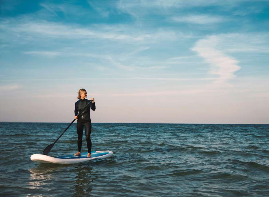 Female Stand up paddleboarding at sea
