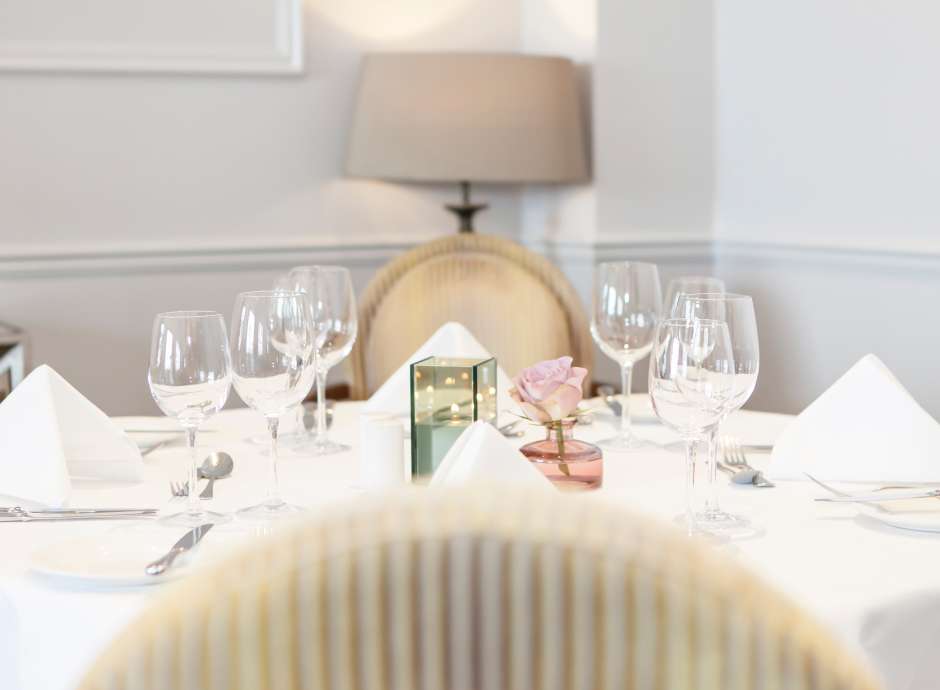 Dining table set for lunch with candle and flowers