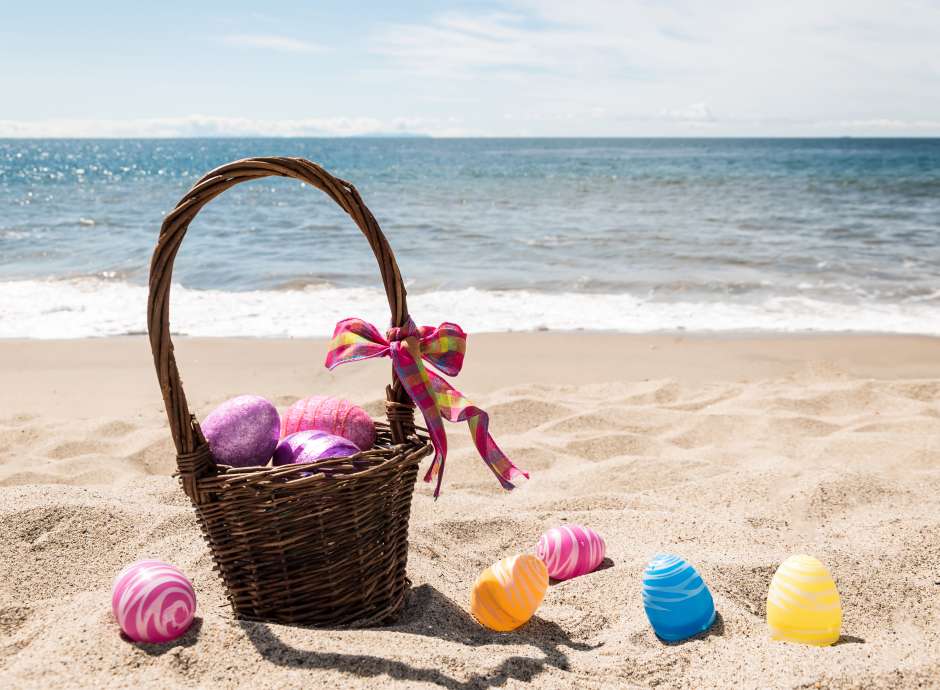 Basket of Easter eggs on the beach 