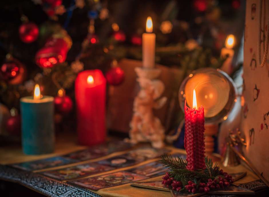 Candles and crystal ball in a dark room with tarot cards on the table