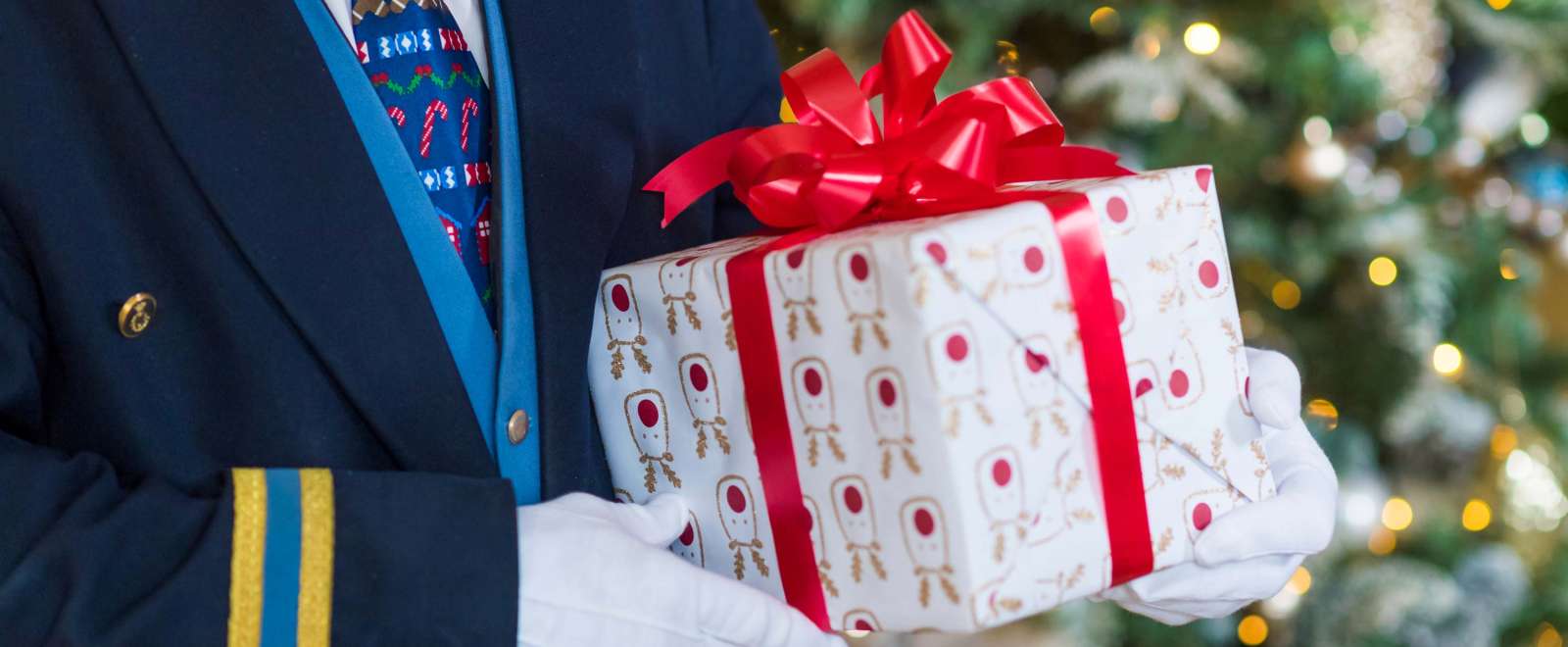 Royal Duchy Hotel Doorman with Festive Tie Holding Christmas Present
