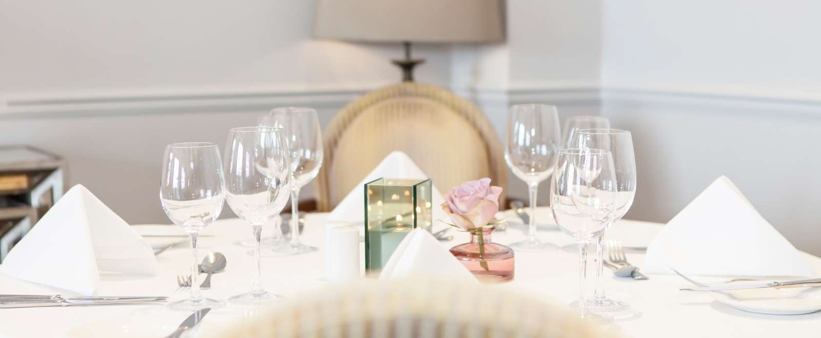 Dining table set for lunch with candle and flowers