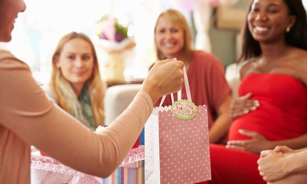 Baby shower pregnant woman and friends sharing gifts