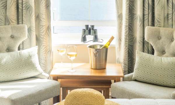 Wine by the window with hat on bed