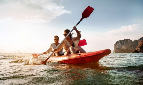 Couple paddling a double kayak on the coast of Cornwall