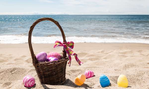 Basket of Easter eggs on the beach 